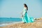 Happy family in a blue dress. Mother with baby on the beach