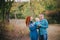 Happy family in blue stylish clothes walking in autumn forest