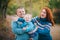 Happy family in blue stylish clothes walking in autumn forest