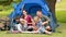 Happy family on a camping trip in front of their tent