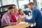 Happy family in car dealership choosing their new car