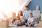 Happy family with cardboard boxes indoors. Moving into new house