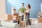 Happy family with cardboard boxes indoors. Moving into new house