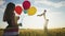 happy family celebrates birthday lifestyle in the park. girl a holding colorful balloons silhouette in the field. dad