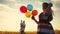 happy family celebrates birthday in the park. girl a holding colorful balloons silhouette in the field. dad lifestyle