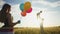 happy family celebrates birthday in the park. lifestyle girl a holding colorful balloons silhouette in the field. dad