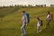 Happy family with child backpacking in mountains. Mother, father and daughter hiking in countryside on summer day