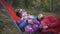 Happy family with child spend time hammock during weekend in camping.