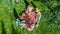 Happy family with children having picnic in park, parents with kids sitting on garden grass and eating healthy meals outdoors