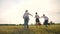 happy family children kids together run in park at sunset silhouette. people in park concept mom a dad daughter and son