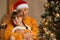 Happy family on Christmas eve, senior man hugging little charming girl with pigtails dresses white shirt, grandpa with grandchild