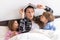 happy family. Close up loving mother lying with daughter son two kids pajamas in bed children reading interesting
