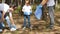 Happy family collects garbage in the forest. Mother and child put garbage in a biodegradable bag. Educate children about