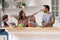 Happy family cooking salad together, smiling mother feeding father