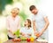 Happy family cooking vegetable salad for dinner