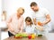 Happy family cooking vegetable salad for dinner