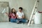 Happy family couple relaxing after painting. Young couple lying on the floor of new house and communicate with each