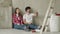 Happy family couple relaxing after painting. Young couple lying on the floor of new house and communicate with each