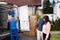 Happy Family Couple Watching Movers Unload Boxes