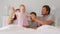 Happy family with cute little kids son daughter tickling having fun relax on bad together, young carefree parents and
