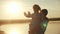Happy family dad and daughter by the sea at sunset silhouette. father and child kid reach out to the sun. kid a dream