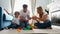 Happy family dad mom and baby 2 years playing lego in their bright living room. Slow-motion shooting happy family