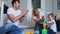 Happy family dad mom and baby 2 years playing lego in their bright living room. Slow-motion shooting happy family