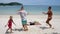 Happy family dance, jump and play on sea beach