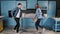 Happy family dance. Young couple fun dancing while cooking in the kitchen at home. Rock and Roll dance moves