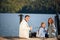 Happy family with daughter fishing in pond in fall