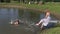 Happy family daughter girl splash pond water and pregnant mother