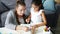 Happy family daughter and mother drawing picture at table in apartment