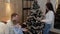 Happy family decorates a Christmas tree in a modern interior.