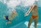 Happy family dive underwater with fun in swimming pool