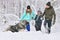 Happy family with dog outdoors in a winter forest. Mother, fother, son and big pet dog.
