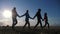 Happy family and dog silhouette walking at sunset teamwork. group of friends people walking holding hands lifestyle slow