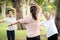 Happy family are doing exercising together at the park,group of asian women stretching arm workout,relaxation after Coronavirus