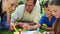 Happy family drawing together while lying on the grass