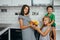 Happy family eating fresh fruit. The concept of healthy eating. funny childs with fruits in the kitchen