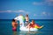 Happy family enjoying summer vacation, having fun in water on inflatable unicorn