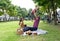 A happy family is enjoying a sunny picnic in the green park with food, laughter, and joy