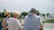 Happy family enjoying vacation. Seniors and their teenage daughter standing in park sightseeing