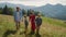 Happy family enjoying walk in mountains. Couple with kids holding hands outdoor.