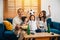 A happy family enjoys the thrill of a football match at home