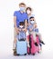 Happy family in face masks holding suitcases standing isolated on white background. People ready for summer vacation, safe travel