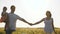 Happy family of farmers with child, are walking on a wheat field. Slow motion. mom, dad and child walk hand in hand