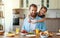 Happy family father with child  feeds his   daughter in kitchen with Breakfast
