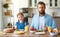 Happy family father with child  feeds his   daughter in kitchen with Breakfast