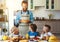 Happy family father with children feeds his sons and daughter in kitchen with Breakfast