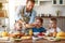 Happy family father with children feeds his sons and daughter in kitchen with Breakfast